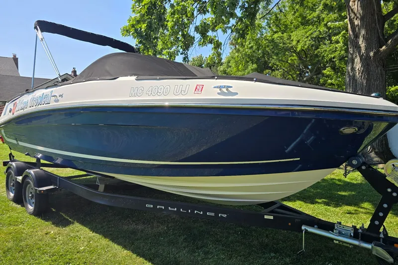 The Image of 2019 Bayliner VR6 Bowrider I/O on trailer, parked on grass under trees. - 0