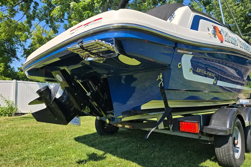 Slide: The Image of 2019 Bayliner VR6 Bowrider I/O on trailer, parked on grass under sunny sky. - 4