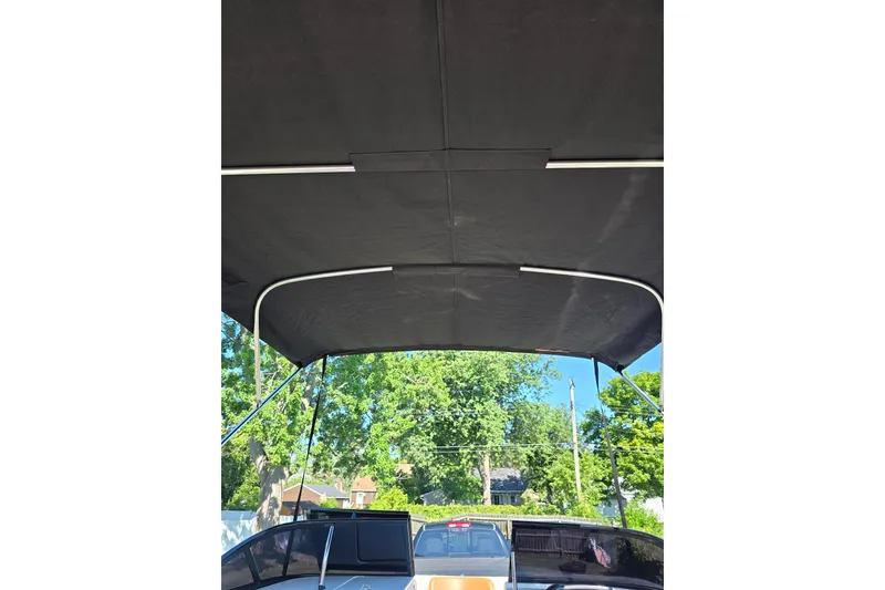 Slide: The Image of 2019 Bayliner VR6 Bowrider I/O with black canopy, parked outdoors. - 9