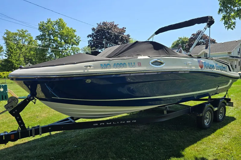 Slide: The Image of 2019 Bayliner VR6 Bowrider I/O boat on trailer, parked on grass. - 1