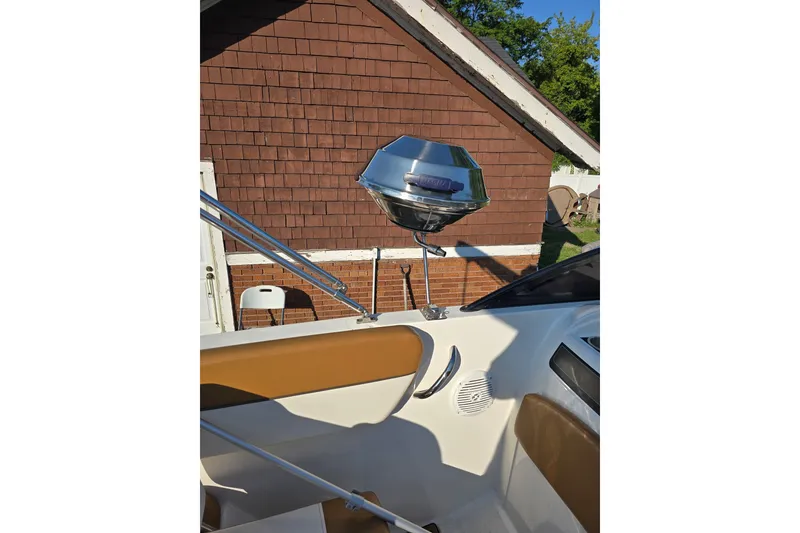 Slide: The Image of 2019 Bayliner VR6 Bowrider I/O interior with mounted grill, near a brick house. - 23