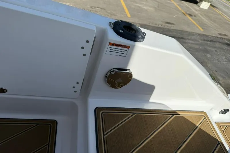 Slide: The Image of 2026 Monterey Elite 27 SD boat deck with warning label and wood-patterned flooring. - 16