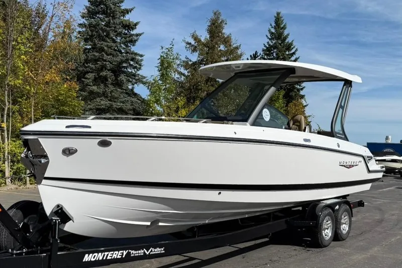 The Image of 2026 Monterey Elite 27 SD boat on trailer, surrounded by trees and clear sky. - 0