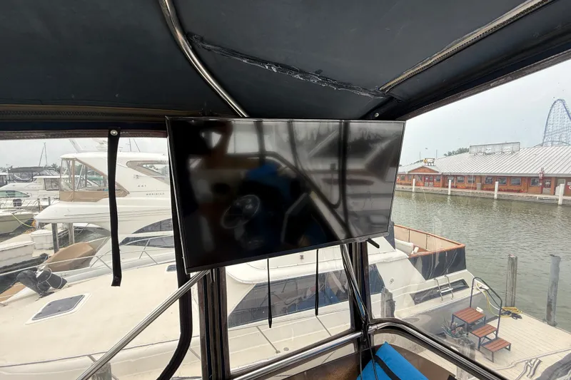 Slide: The Image of 1987 Sea Ray 410 Aft Cabin yacht interior with mounted TV, docked at marina. - 45