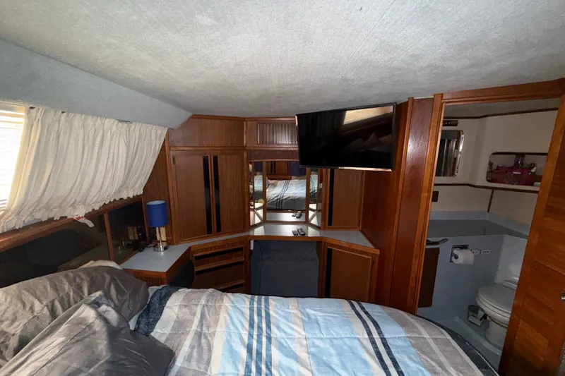 Slide: The Image of Interior of 1987 Sea Ray 410 Aft Cabin with bed, TV, and bathroom. - 31