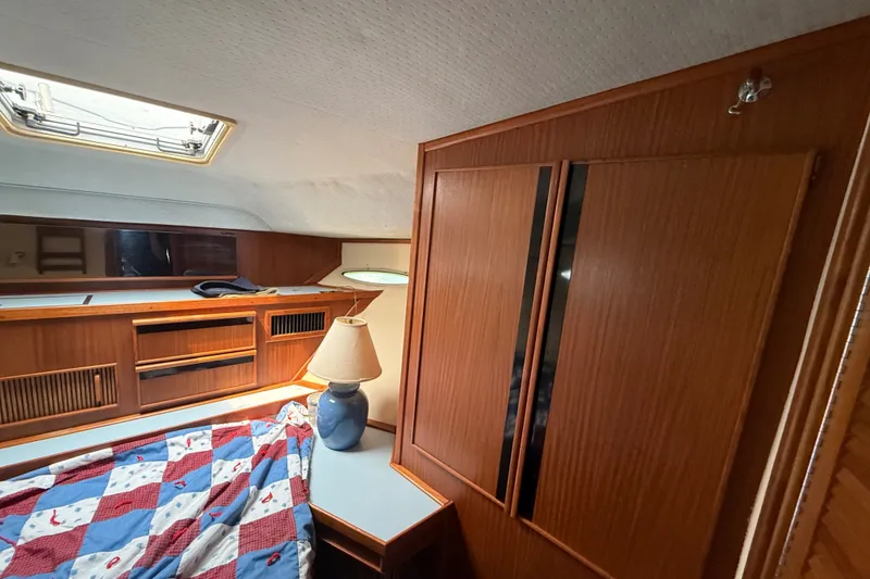 Slide: The Image of Interior of 1987 Sea Ray 410 Aft Cabin with wood paneling and cozy bedding. - 24