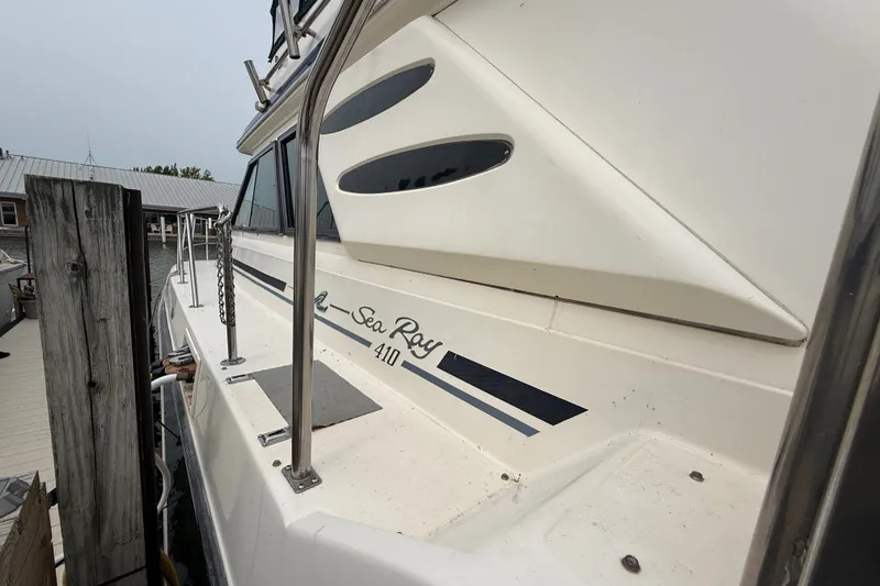 Slide: The Image of 1987 Sea Ray 410 Aft Cabin yacht docked, showcasing sleek design and branding. - 4