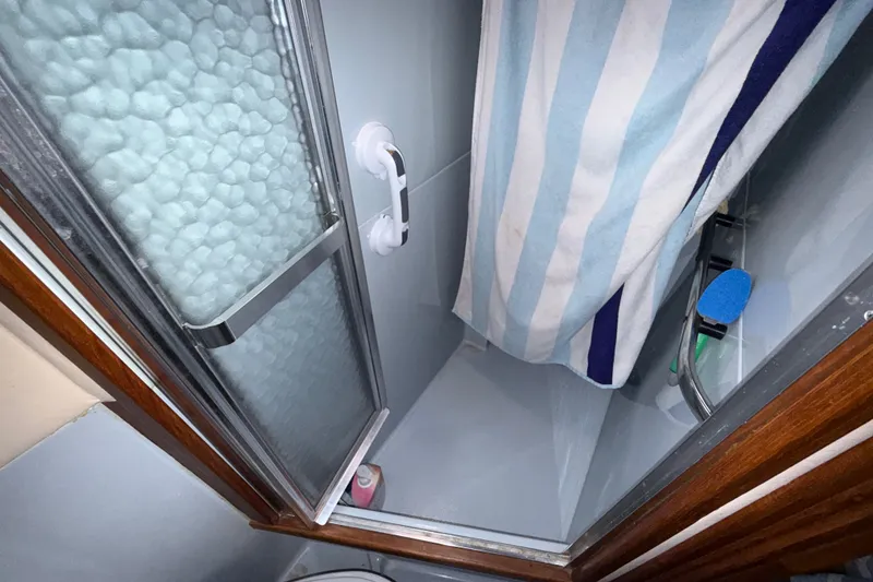 Slide: The Image of Shower area in 1987 Sea Ray 410 Aft Cabin yacht with striped curtain and glass door. - 36