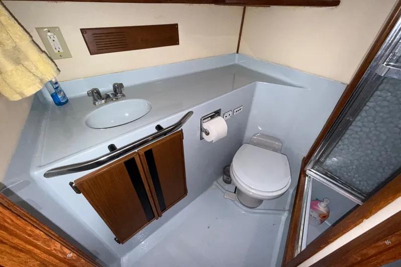 Slide: The Image of 1987 Sea Ray 410 Aft Cabin bathroom with sink, toilet, and shower. - 34