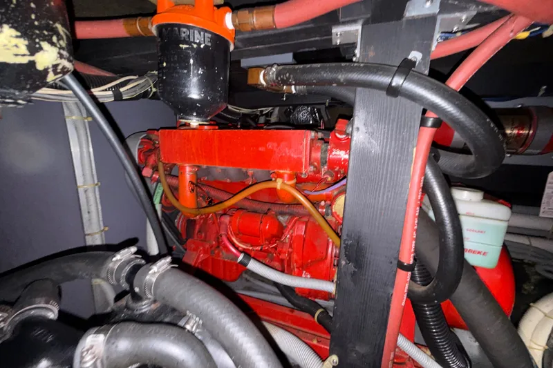 Slide: The Image of Engine compartment of a 1987 Sea Ray 410 Aft Cabin boat, featuring red engine components. - 40