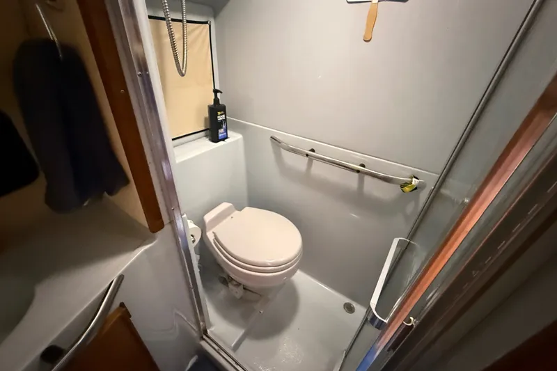 Slide: The Image of 1987 Sea Ray 410 Aft Cabin bathroom with toilet and shower area. - 28