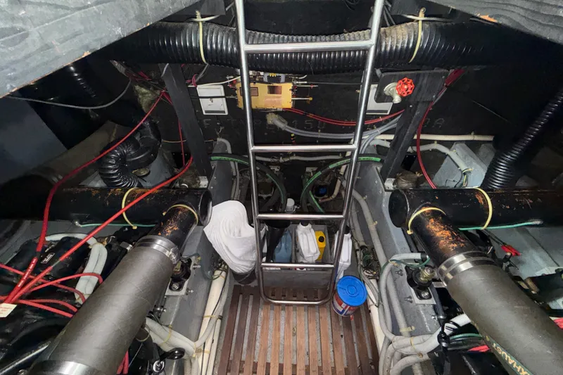 Slide: The Image of Engine room of 1987 Sea Ray 410 Aft Cabin with visible pipes and wiring. - 39