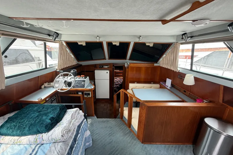 Slide: The Image of Interior of a 1987 Sea Ray 410 Aft Cabin yacht with helm, seating, and wood accents. - 9