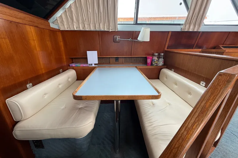 Slide: The Image of 1987 Sea Ray 410 Aft Cabin interior with wood paneling and white cushioned seating. - 21