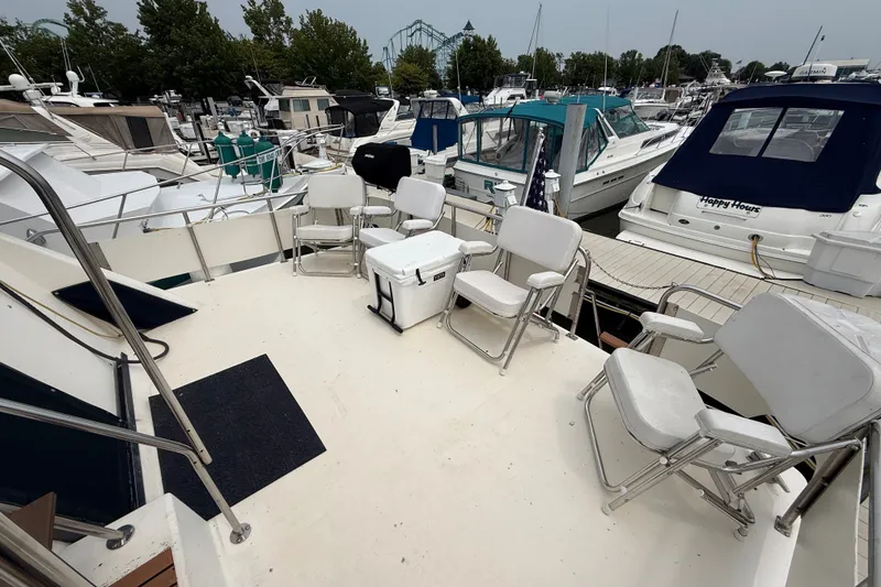 Slide: The Image of 1987 Sea Ray 410 Aft Cabin yacht deck with chairs, docked at marina. - 6