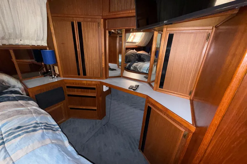 Slide: The Image of Interior of 1987 Sea Ray 410 Aft Cabin with wood cabinetry and cozy bedding. - 32