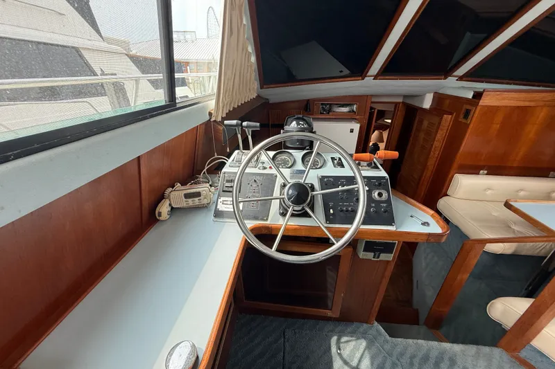 Slide: The Image of 1987 Sea Ray 410 Aft Cabin helm with classic wooden interior and navigation controls. - 10