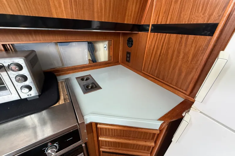 Slide: The Image of 1987 Sea Ray 410 Aft Cabin kitchen with wood cabinetry and modern appliances. - 19