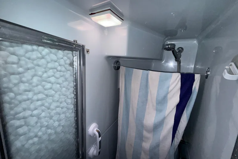 Slide: The Image of Shower area in 1987 Sea Ray 410 Aft Cabin with striped curtain and textured glass door. - 35