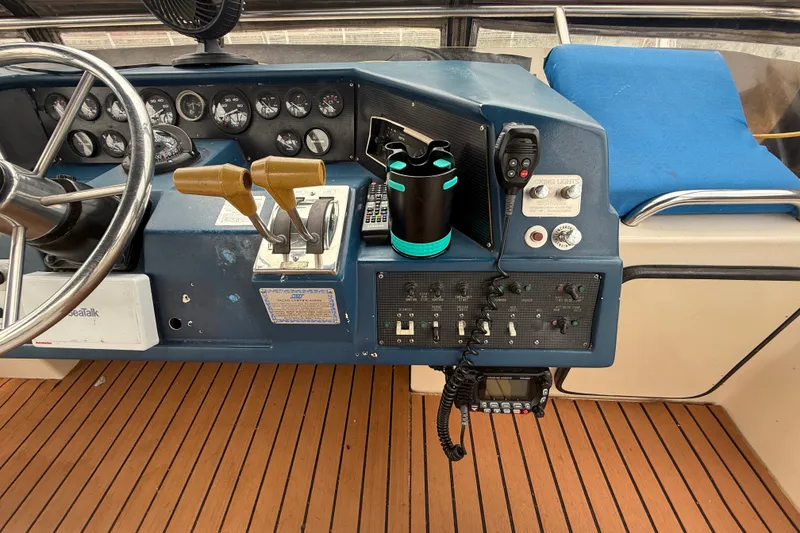 Slide: The Image of 1987 Sea Ray 410 Aft Cabin helm with controls, gauges, and wooden deck. - 46
