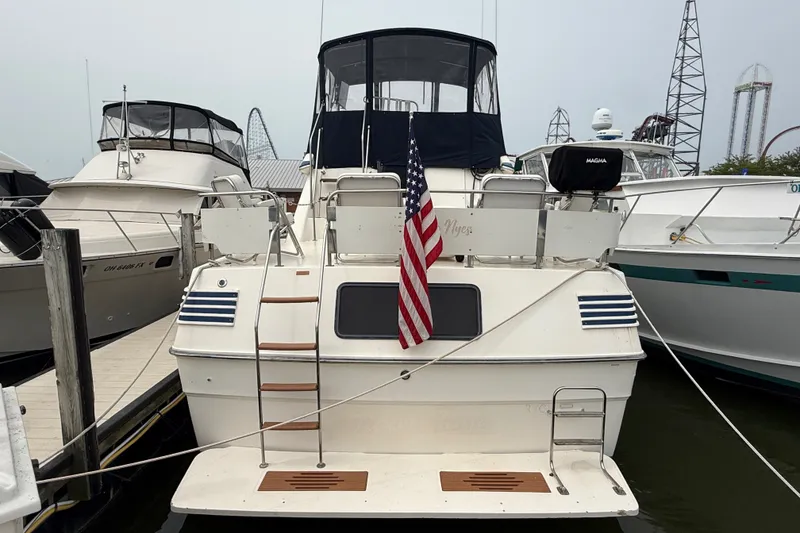 Slide: The Image of 1987 Sea Ray 410 Aft Cabin yacht docked with American flag displayed. - 2
