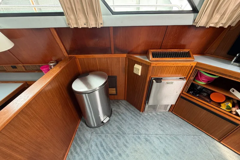Slide: The Image of 1987 Sea Ray 410 Aft Cabin interior with wood paneling, mini fridge, and trash can. - 12