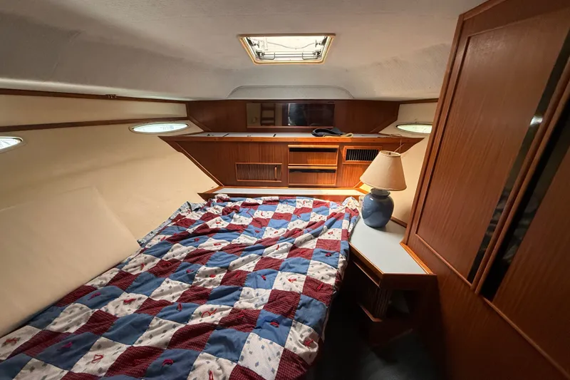 Slide: The Image of Cozy cabin interior of 1987 Sea Ray 410 Aft Cabin with quilted bedspread. - 22
