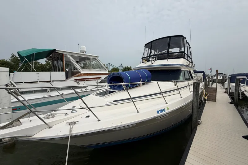 The Image of 1987 Sea Ray 410 Aft Cabin yacht docked at marina, featuring sleek design and spacious deck. - 5