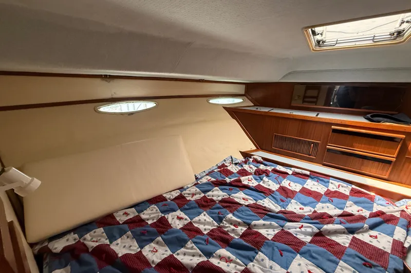Slide: The Image of 1987 Sea Ray 410 Aft Cabin interior with quilted bed and wooden cabinetry. - 23