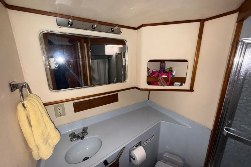 Slide: The Image of 1987 Sea Ray 410 Aft Cabin bathroom with sink, mirror, and shower. - 33