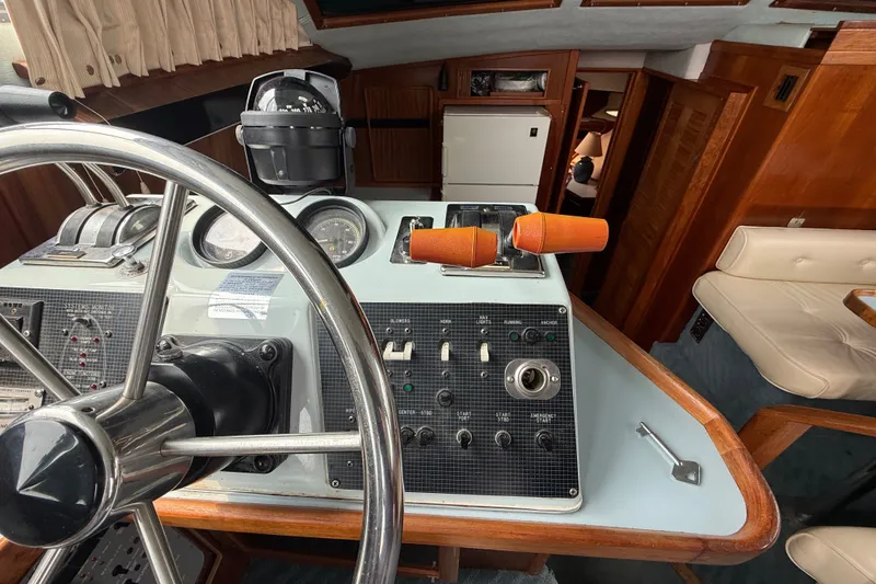 Slide: The Image of 1987 Sea Ray 410 Aft Cabin helm with steering wheel and control panel. - 11