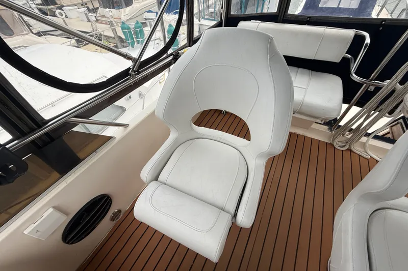 Slide: The Image of 1987 Sea Ray 410 Aft Cabin interior with white seating and wooden flooring. - 52