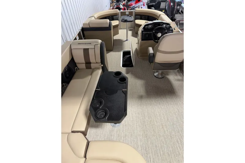 Slide: The Image of 2025 Berkshire 24CL CTS pontoon boat interior with beige seating and black table. - 3