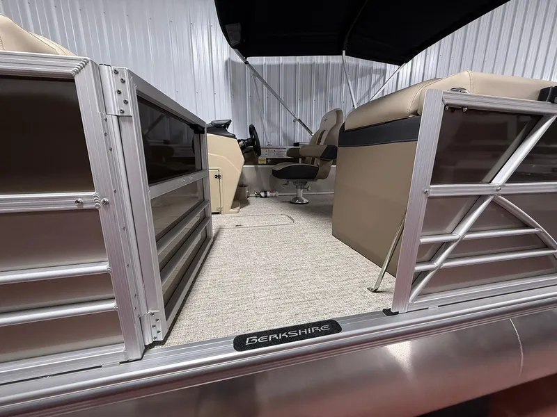 Slide: The Image of 2025 Berkshire 24CL CTS pontoon boat interior with beige seating and aluminum railings. - 8