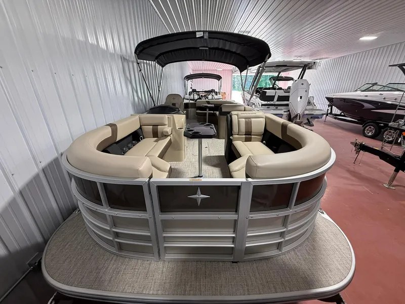 Slide: The Image of 2025 Berkshire 24CL CTS pontoon boat with beige seating, displayed indoors. - 1