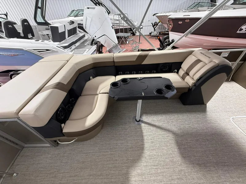 Slide: The Image of 2025 Berkshire 24CL CTS pontoon boat interior with beige seating and black table. - 2