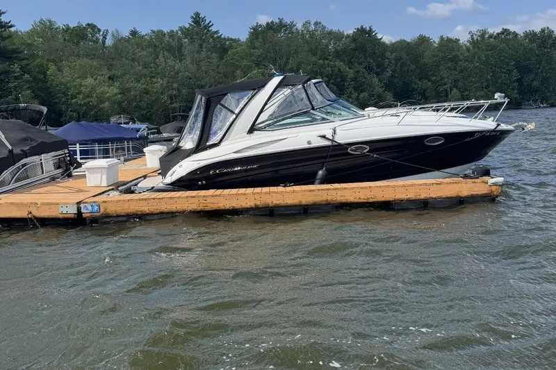 Slide: The Image of 2010 Crownline 280 CRX boat docked on a lake with forested background. - 5