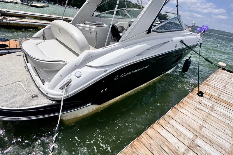 Slide: The Image of 2010 Crownline 280 CRX boat docked on a sunny day, featuring sleek design and comfortable seating. - 2