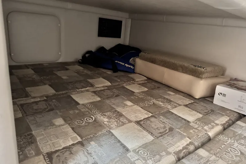 Slide: The Image of Interior cabin of 2010 Crownline 280 CRX boat with patterned bedding and storage. - 3
