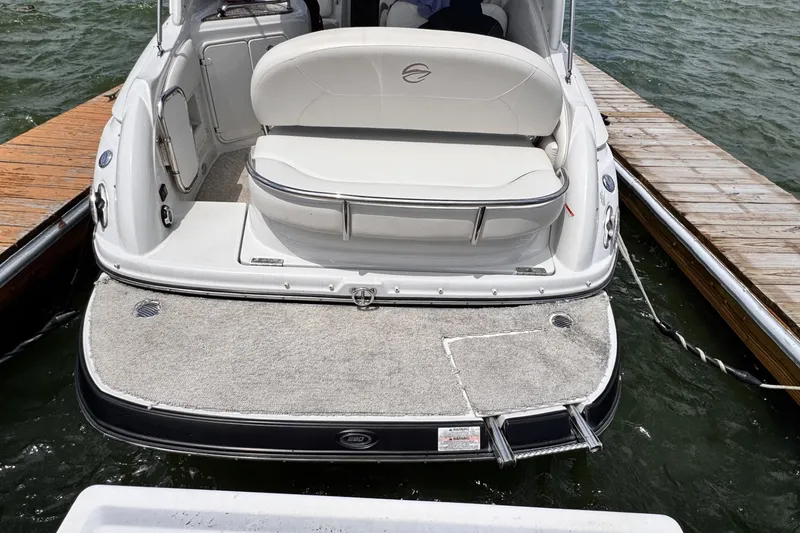 Slide: The Image of 2010 Crownline 280 CRX boat docked, featuring spacious seating and swim platform. - 6