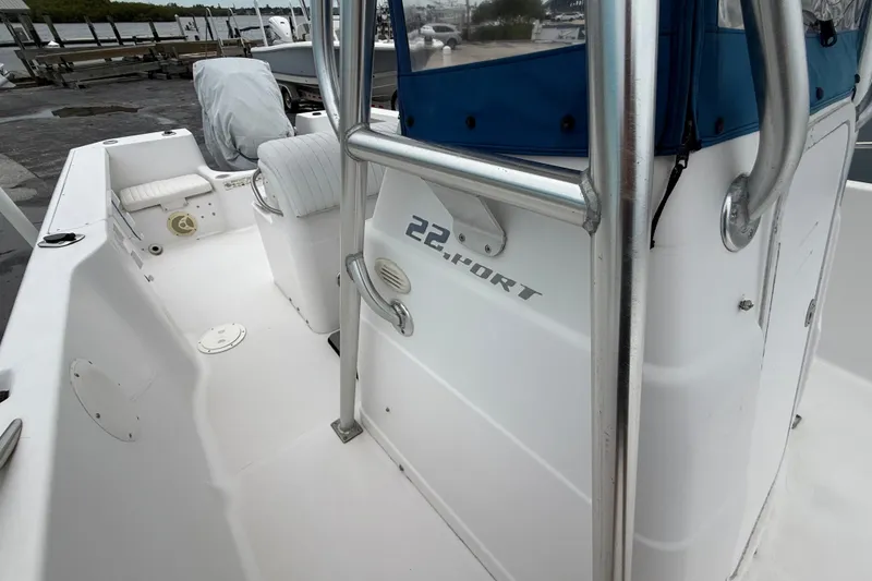 Slide: The Image of 2003 Pro-Line 22 Sport boat interior with seating and console, docked near water. - 17