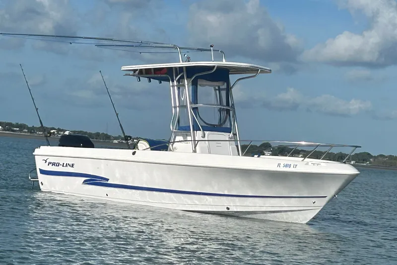 The Image of 2003 Pro-Line 22 Sport boat on calm water under a partly cloudy sky. - 1