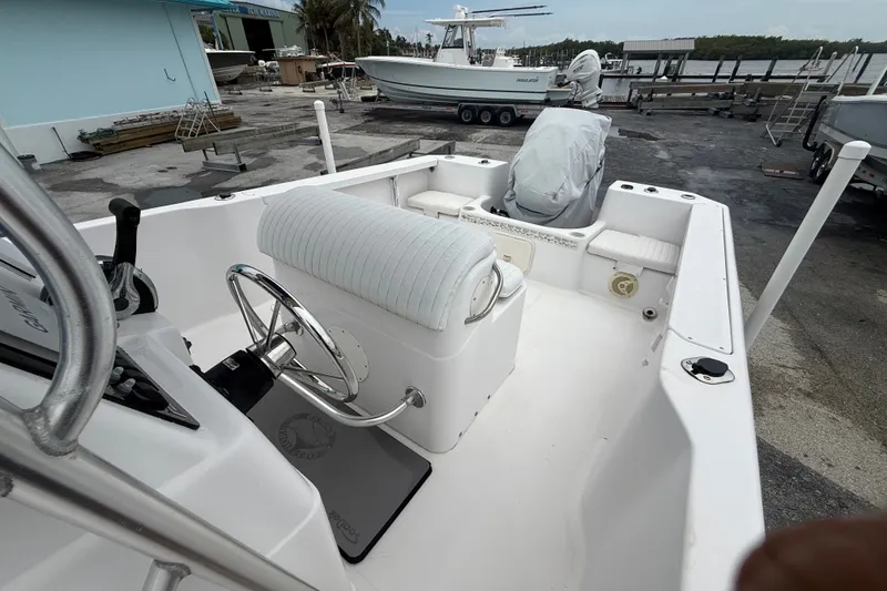 Slide: The Image of 2003 Pro-Line 22 Sport boat interior with steering wheel and seating, docked at marina. - 16