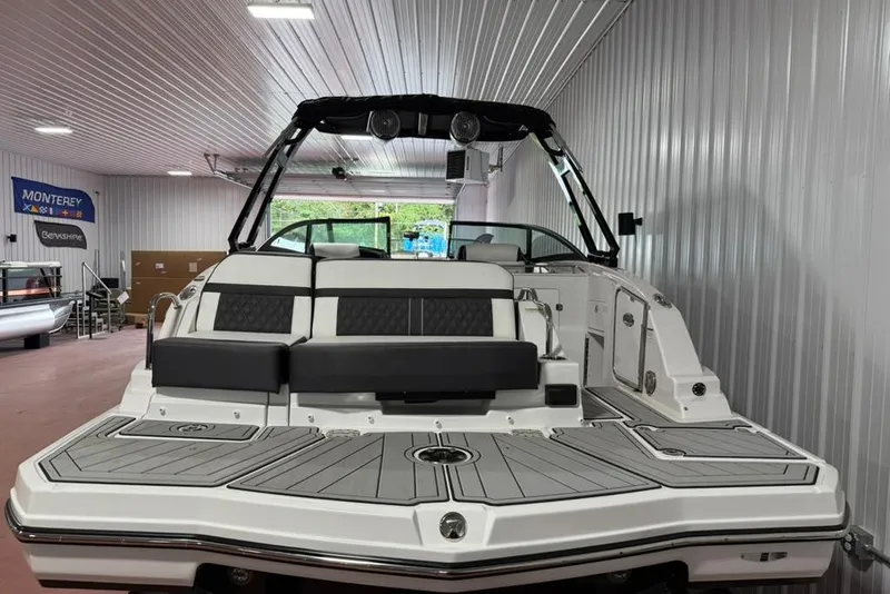 Slide: The Image of 2025 Monterey M6 boat in showroom, featuring sleek design and spacious seating. - 2