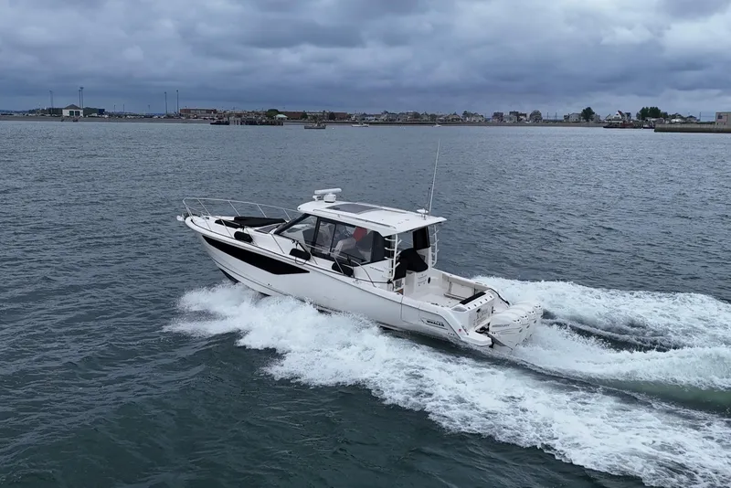 Slide: The Image of 2021 Boston Whaler 405 Conquest cruising on open water under cloudy skies. - 16