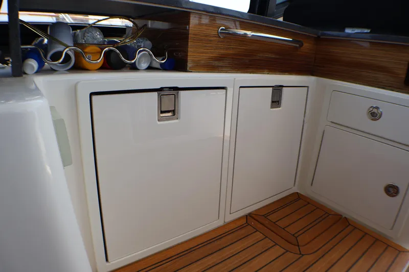 Slide: The Image of Interior storage cabinets on 2021 Boston Whaler 405 Conquest boat with wooden flooring. - 38