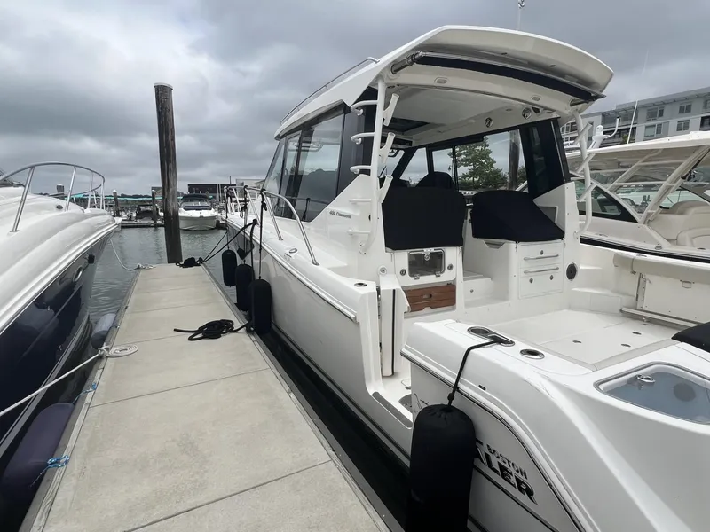 Slide: The Image of 2021 Boston Whaler 405 Conquest docked at marina under cloudy skies. - 21