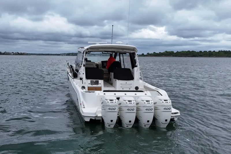 Slide: The Image of Boston Whaler 405 Conquest 2021 boat with four engines on a calm lake. - 9
