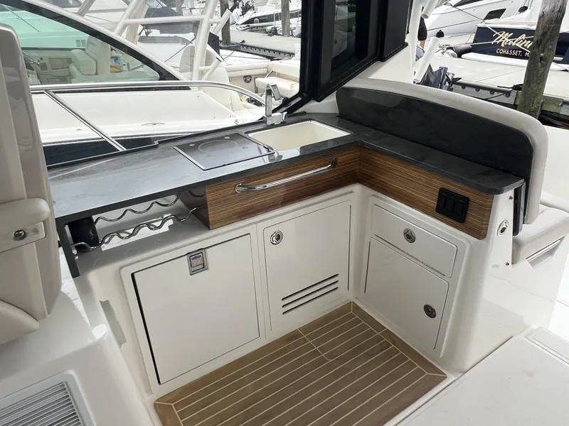 Slide: The Image of Boston Whaler 405 Conquest 2021 boat interior with sleek kitchenette and storage cabinets. - 26