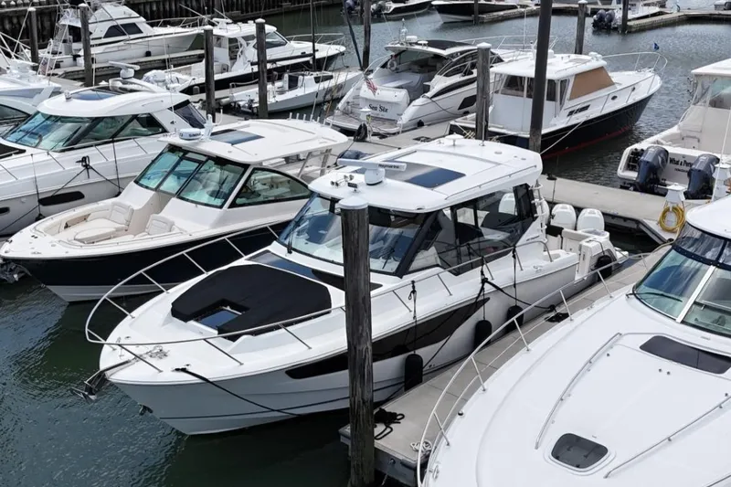 Slide: The Image of 2021 Boston Whaler 405 Conquest docked among other boats in a marina. - 20